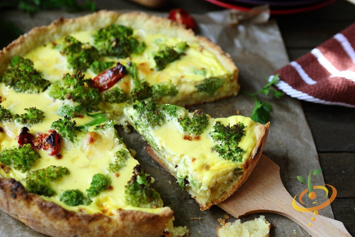 Broccoli Di Cicco seed quiche with roasted broccoli and sun-dried tomatoes on wooden board